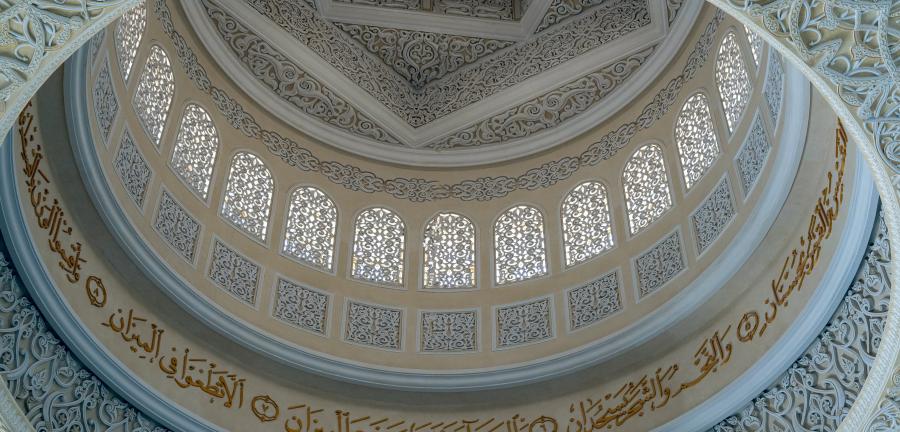 Interior dome of a mosque covered in calligraphy