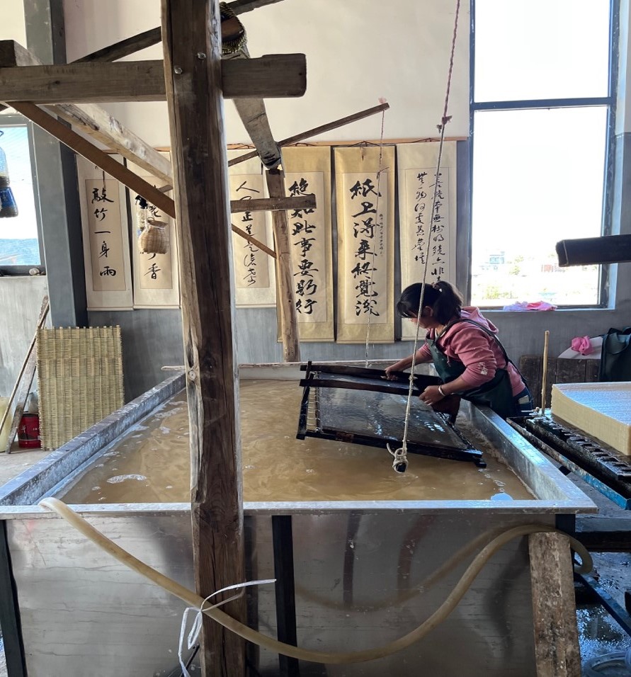This photo was taken during my brief field trip to West Yunnan (November 2022), a village known for its handcrafts of paper-making. The woman here was lifting a wooden framework from paper pulp, a crucial procedure for making paper. 
