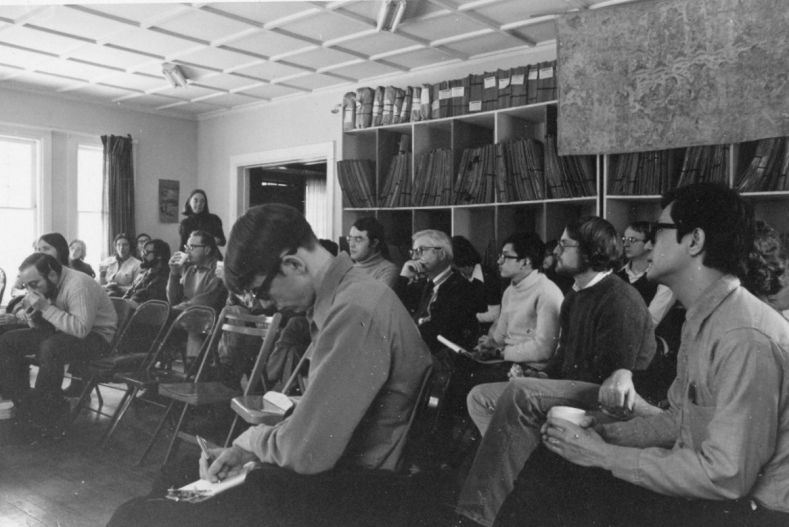 students and faculty intently listening at 102 West Ave.