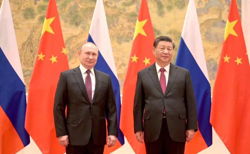 Vladamir Putin and Xi Jinping stand in front of flags of Russia and China (CC 4.0 Wikipedia)