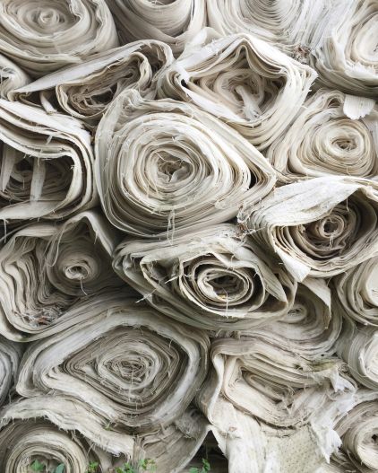 A pile of rolls of paper or thin textile.