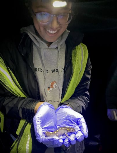 Trisha Bhujle holds a salamander in her hands.