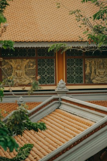 The roof of a temple, with Buddhist motifs visible in the background. 