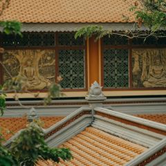 The roof of a temple, with Buddhist motifs visible in the background. 