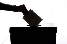 Hand placing ballot in voting box