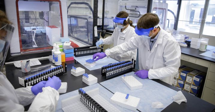 Cornell research collaboration, lab workers at microscope