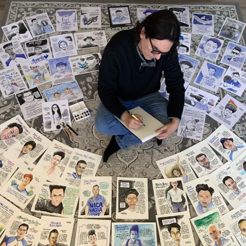 Cartoonist Pedro Molina sitting among his political cartoons
