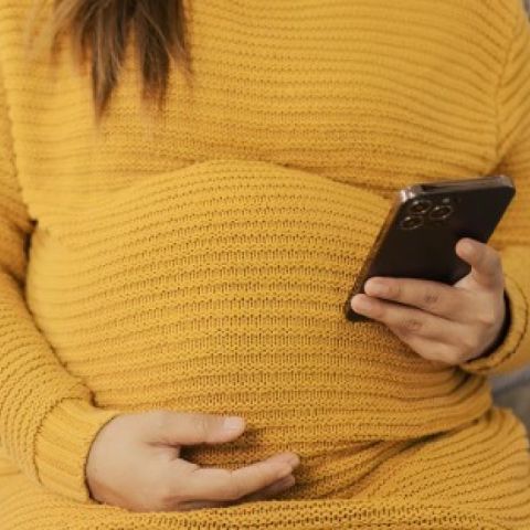 Pregnant person holding phone