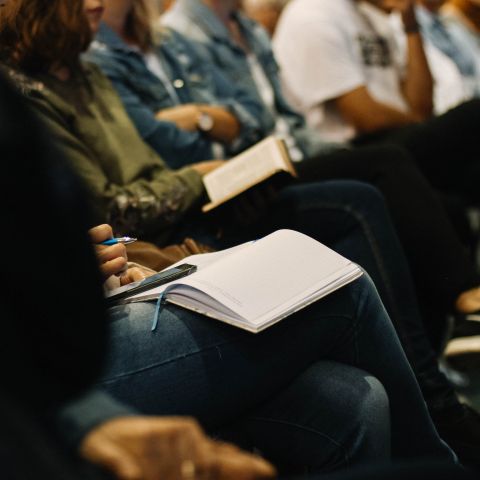Students taking notes in notebooks during class