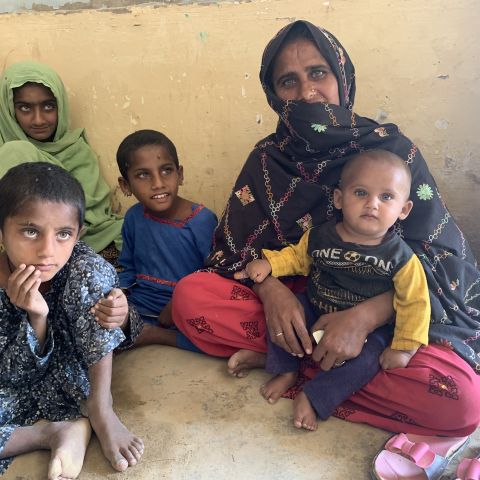 A woman sits with her children.