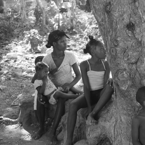 A woman and children staring into the distance.