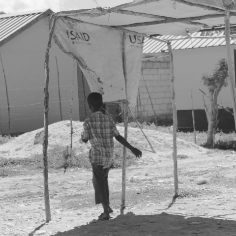 Young boy in a temporary shelter encampment constructed by USAID.
