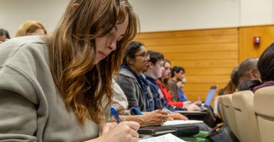 A student in the audience at the Lund Debate takes notes.
