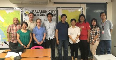 Lindy Williams stands with city officials in Malobon, Philippines